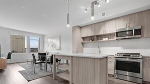 Una cocina moderna con una isla central, electrodomésticos de acero inoxidable y armarios de madera clara.