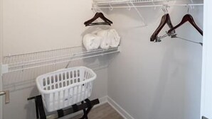 Une buanderie équipée d’étagères pour suspendre les vêtements, d’un panier à linge et d’un banc en bois.