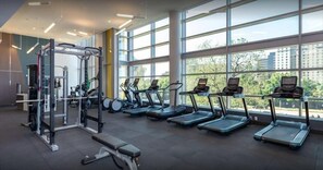 A gym with treadmills, a weight machine, and a bench.