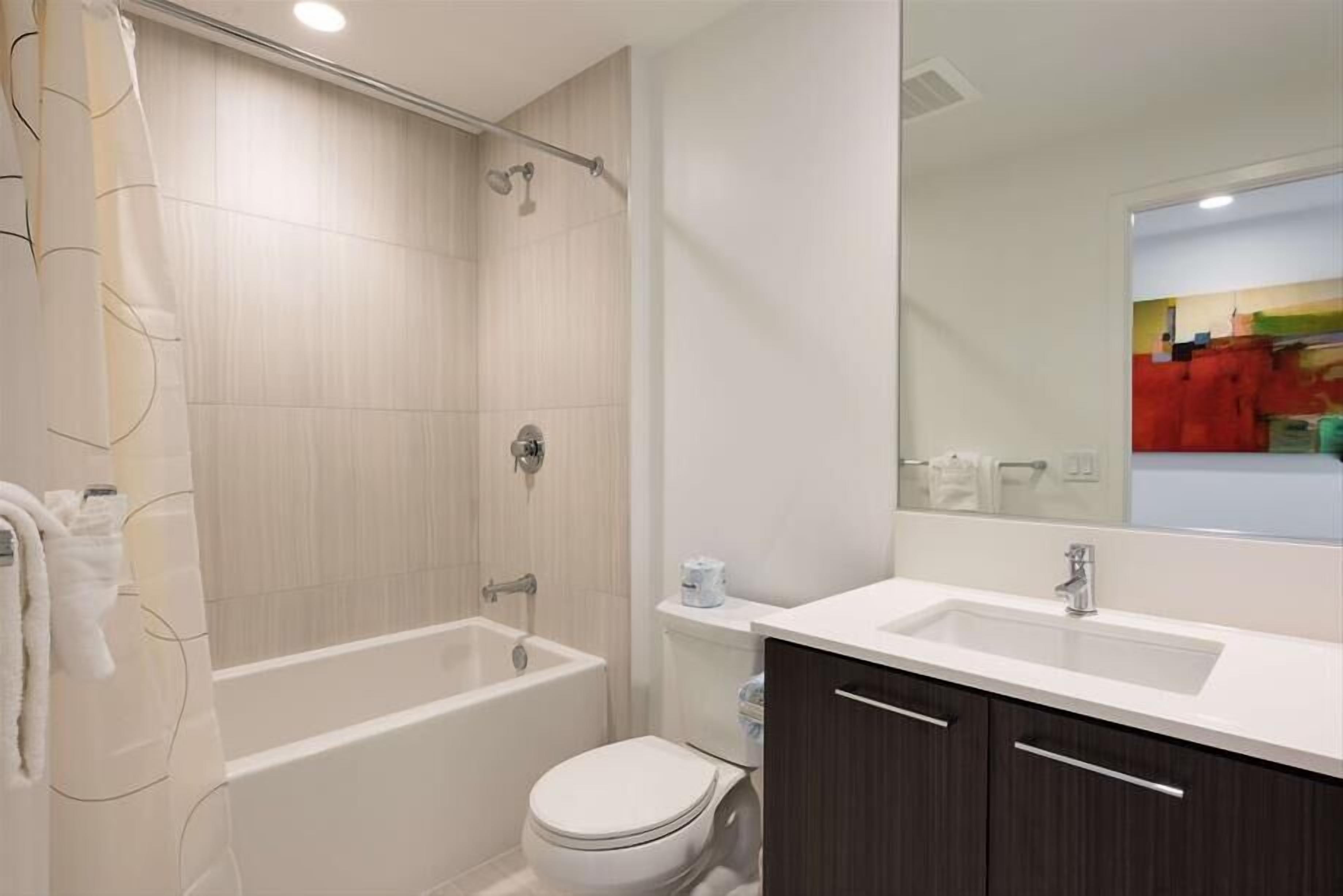A modern bathroom with a bathtub, toilet, and sink.
