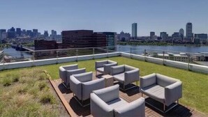 Una terrazza sul tetto con posti a sedere all'aperto e vista sullo skyline cittadino.
