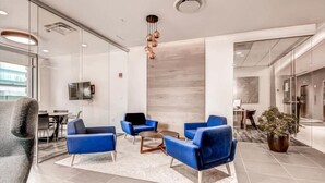 Una zona relax moderna con divani blu, un tavolino da caffè e una pianta in vaso.