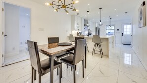 A modern kitchen with white cabinets, a central island, and pendant lighting. - Pet-Friendly St Augustine Home: 2 Mi to Downtown! (St. Augustine)
