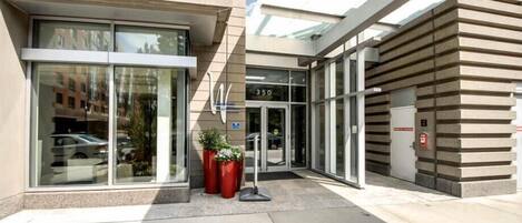 A modern building with a glass entrance, a visible door number 350, and a fire alarm box on the right.