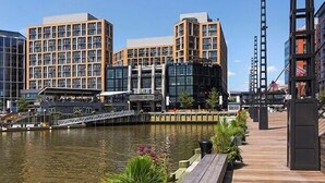 Ein Hotel direkt am Wasser, bestehend aus mehreren Gebäuden, einem Steg und einer Holzpromenade.