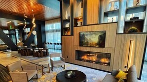 Ein modernes Wohnzimmer mit Kamin, Sitzgruppe und Einbauschränken.