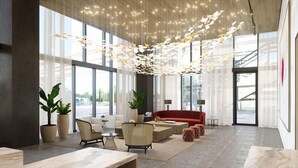 Un vestíbulo amplio con ventanas grandes, un sofá rojo y muebles modernos.