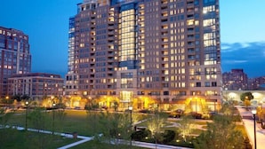 A high-rise building with multiple floors, large windows, and a well-lit facade.
