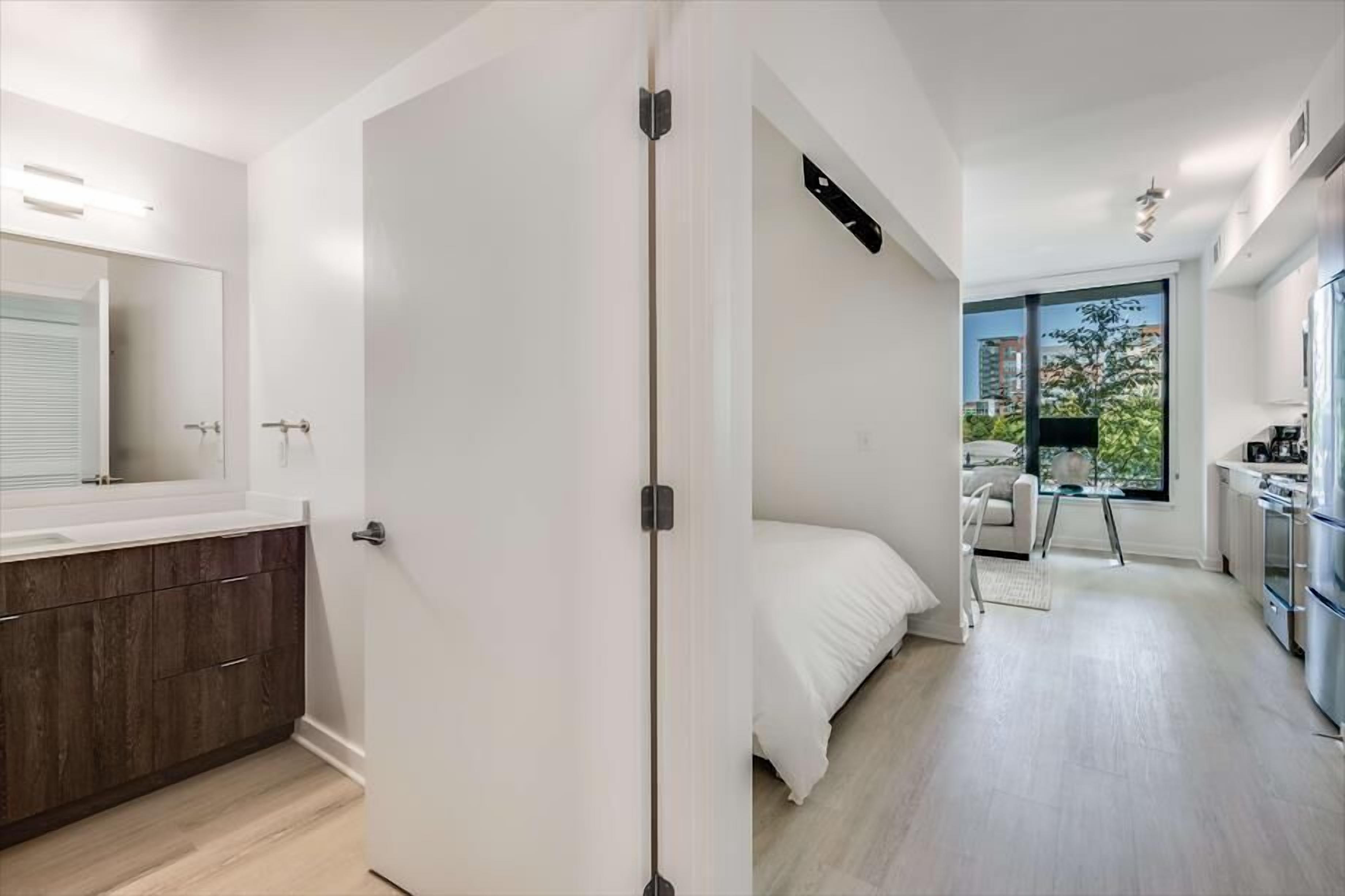 Un apartamento moderno con baño, un dormitorio y una kitchenette.