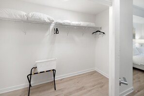 Une chambre d’hôtel comprenant un lit, un petit coin salon et un portant à vêtements.
