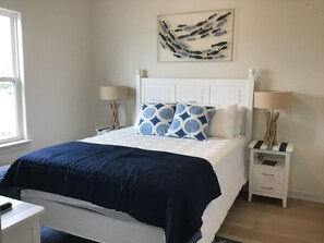 A neatly arranged bedroom with a bed, bedside tables, and a wall art piece. - The Serenity Spot - 137TP (Laguna Vista)