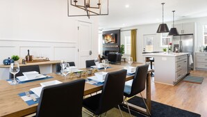 A modern kitchen with white cabinets, a built-in oven, and a stainless steel refrigerator. - Hot Tub • Fire Pit • Chef’s Kitchen • Near Uptown (Charlotte)
