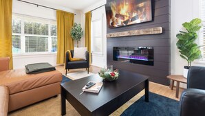 A modern living room with a fireplace, a flat-screen TV, and a comfortable seating area. - Hot Tub • Fire Pit • Chef’s Kitchen • Near Uptown (Charlotte)