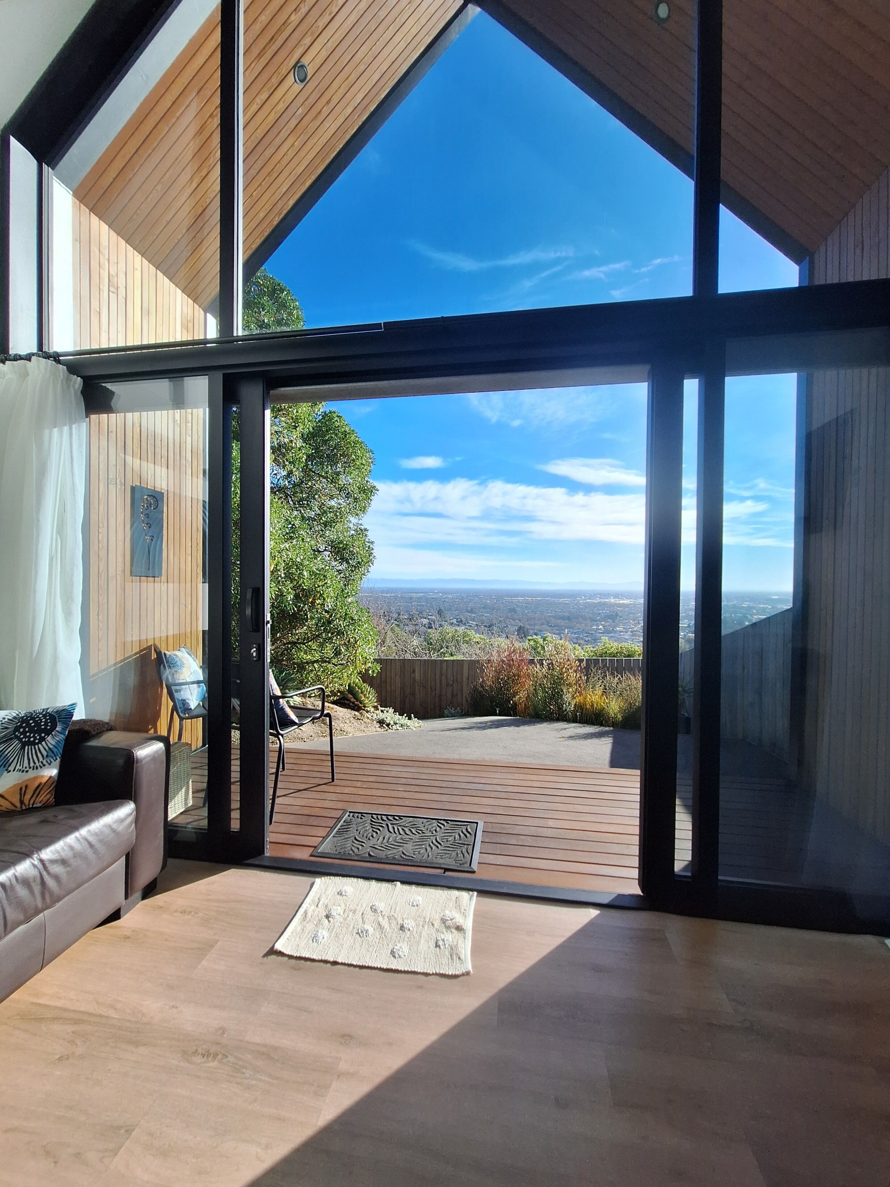 A modern interior with a large glass door leading to an outdoor patio.