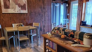 Ein gemütliches Zimmer mit einem Holztisch, Stühlen und einem Bücherregal.
