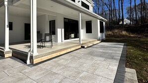 Ein zweistöckiges Haus mit überdachter Terrasse.