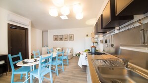 A compact kitchen with a dining area, featuring a sink, stove, and modern appliances.