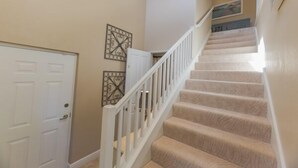 A carpeted staircase with white railings leading to a landing. - Prentiss Pointe Condo - 3 bedroom, 2 bath, 2-Floor Condo in Ft Myers (Fort Myers)