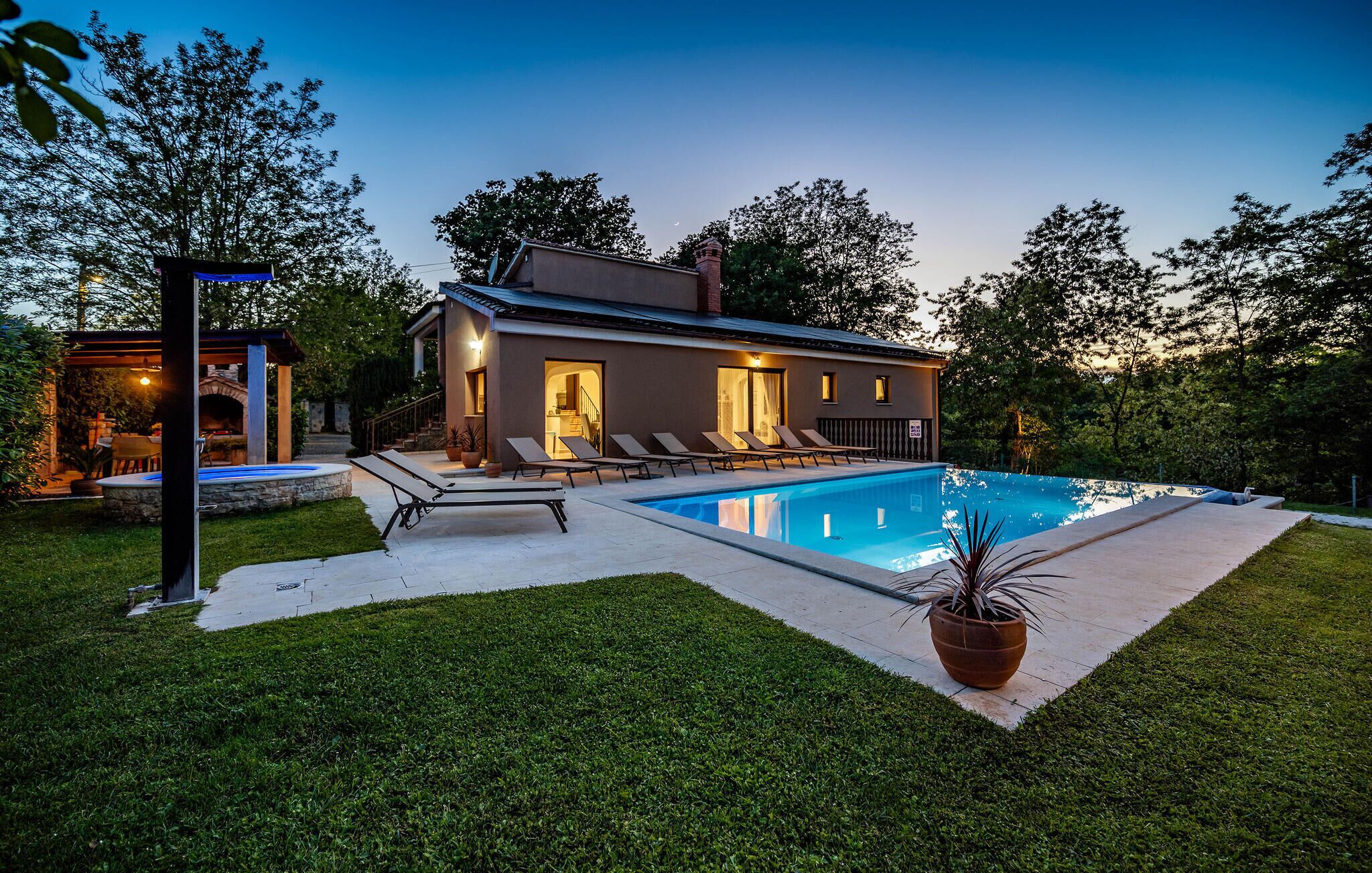 Uma casa moderna com piscina, área de estar externa e gramado bem cuidado.