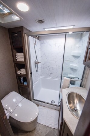 Une salle de bain compacte avec une douche à parois de verre, des toilettes et un lavabo.