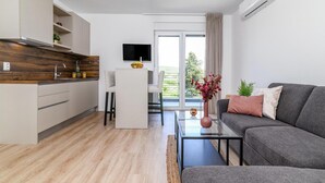 A modern living space with a kitchen, dining area, and a sofa.