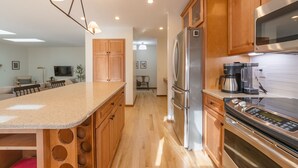 Una cocina moderna con armarios de madera, electrodomésticos de acero inoxidable y una isla central.