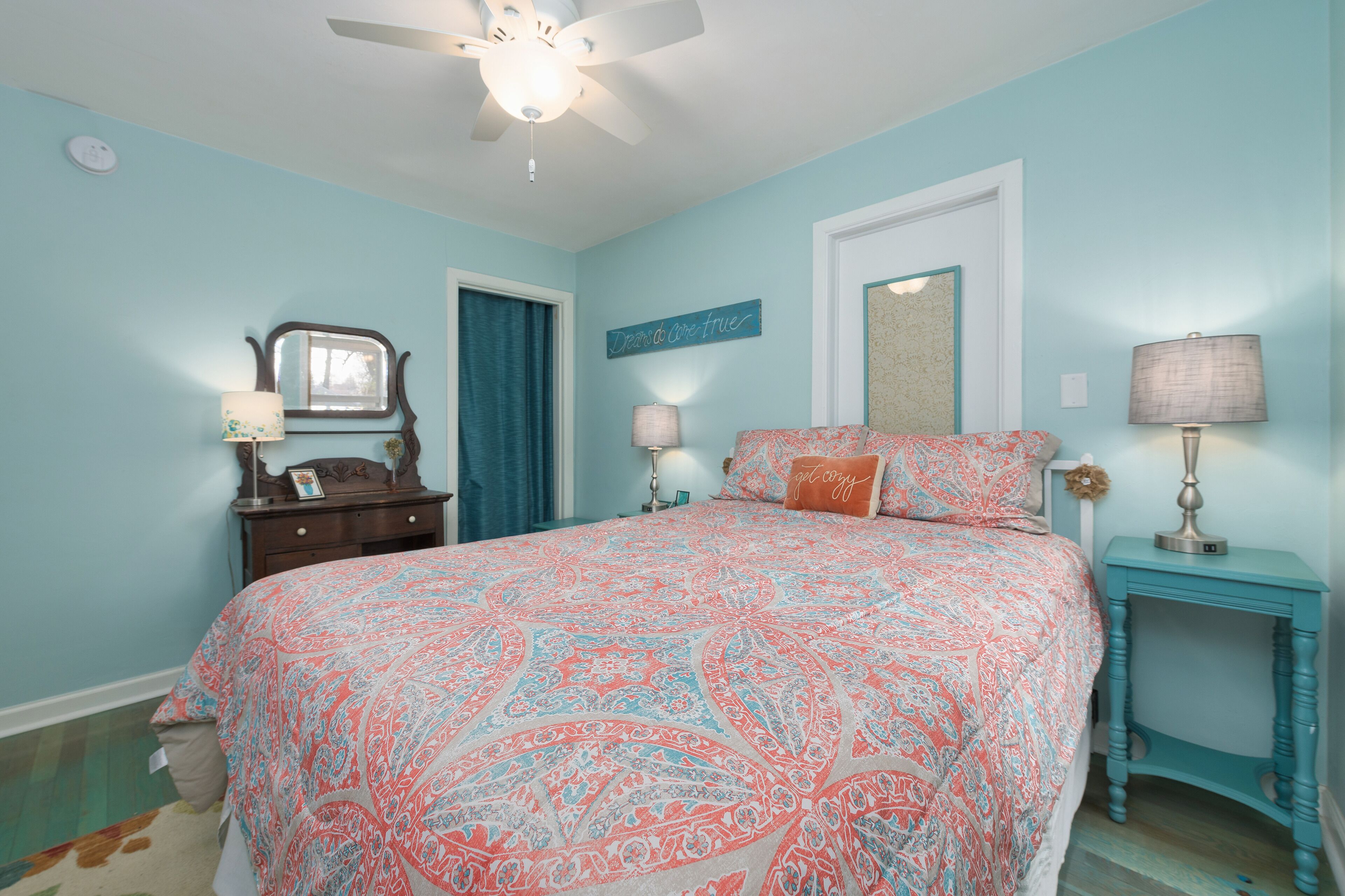 A bedroom with a bed, dresser, and nightstands.