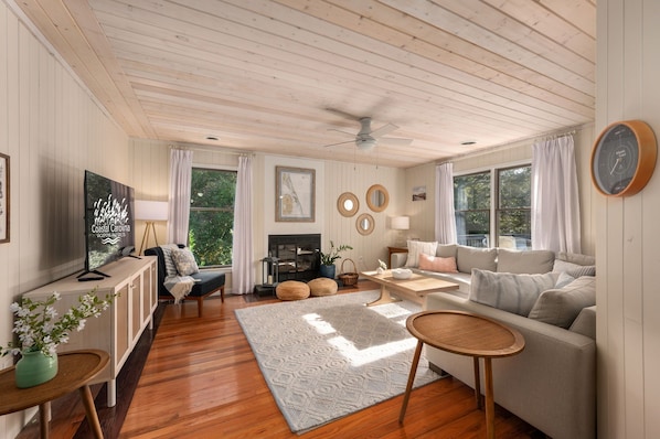 A cozy living room with a fireplace, comfortable seating, and a television.