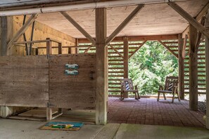 A wooden structure with a covered porch, a bench, and a sign indicating 'Outer Banks'.