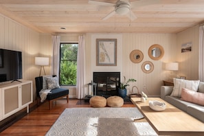 A living room with a television, sofa, coffee table, and a fireplace.