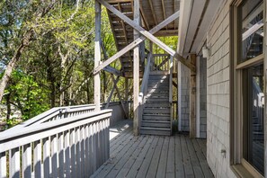 A wooden deck with a railing, leading to a covered area with a sloped roof. - Coastal Hideaway: Private Pool, Walk to the Beach, Perfect for Families (Southern Shores)