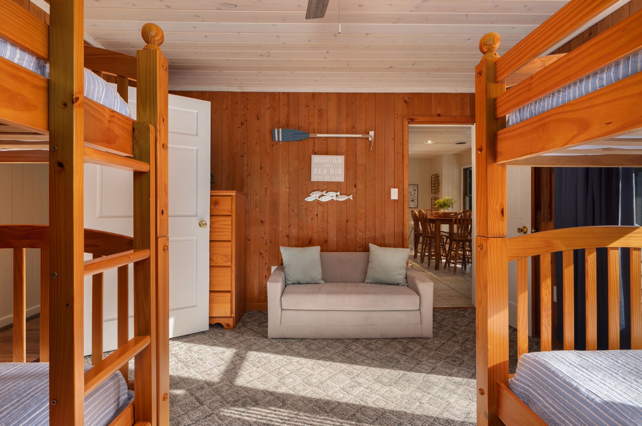 A cozy room with bunk beds, a sofa, and a dining area.