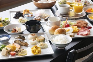 A breakfast buffet with various dishes, including eggs, meats, and vegetables, arranged on a large table. - Kurobe view hotel (Omachi)