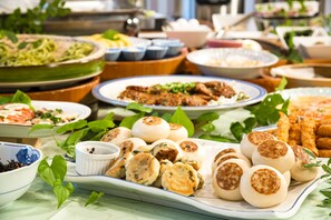 A buffet with various dishes, including dumplings and a large green vegetable dish. - Kurobe view hotel (Omachi)