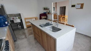 Une cuisine compacte dotée d’un îlot central, d’un évier intégré et d’une cuisinière.