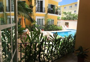 A balcony with a pool, surrounded by potted plants and outdoor furniture. - Charm condo 5 min from the beach! 2-bedroom condo with balconies. (Crucecita)