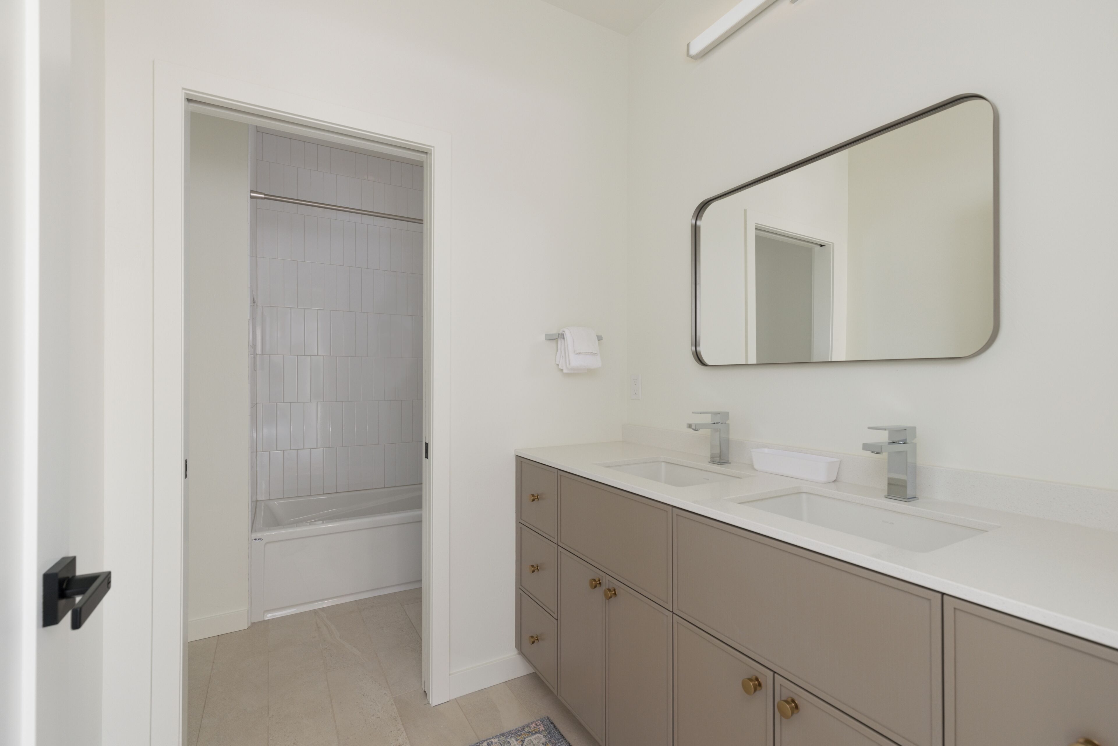 A modern bathroom with a white sink, a mirror, and a shower.