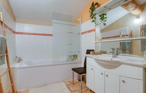A bathroom with a bathtub, a sink, and a mirror. - Awesome home in Artigues (Artigues)