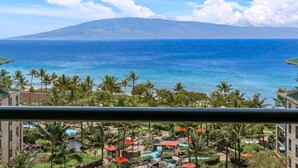 A resort with a pool area, palm trees, and a view of the ocean and a mountain. - Maui Resort Rentals: Honua Kai – 5 Total Bedrooms, 9th Floor Stunning Deluxe Ocean and West Maui Mountain Views! (Lahaina)