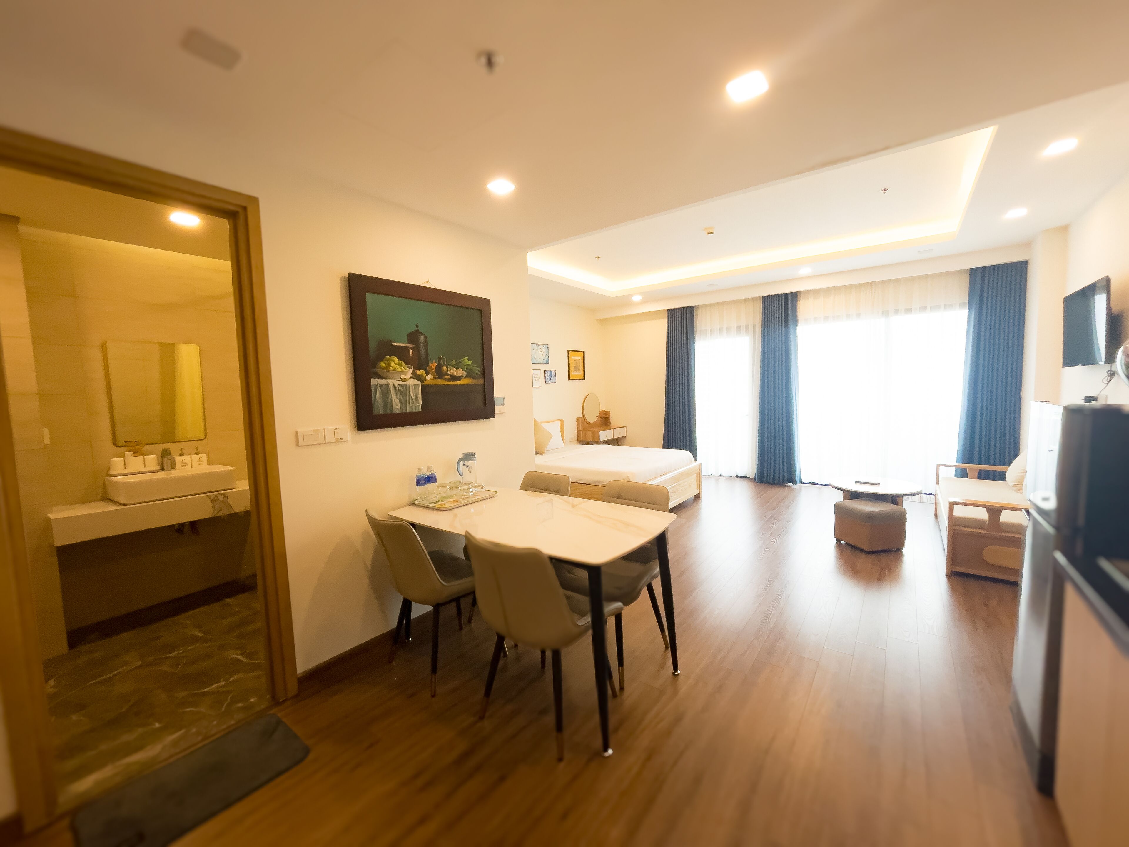 Une chambre d’hôtel comprenant un coin repas, un lit, une télévision et une salle de bain.