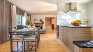 A modern kitchen with a central island, a dining area with a table and chairs, and a staircase leading to another level. - Son Alcaines Sineu by Interhome (Sineu)