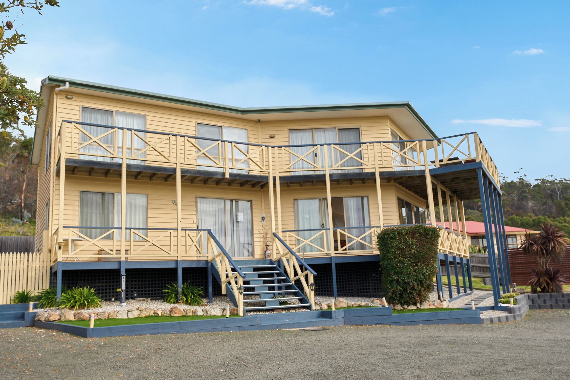 A two-story building with a balcony and a staircase leading to the entrance.
