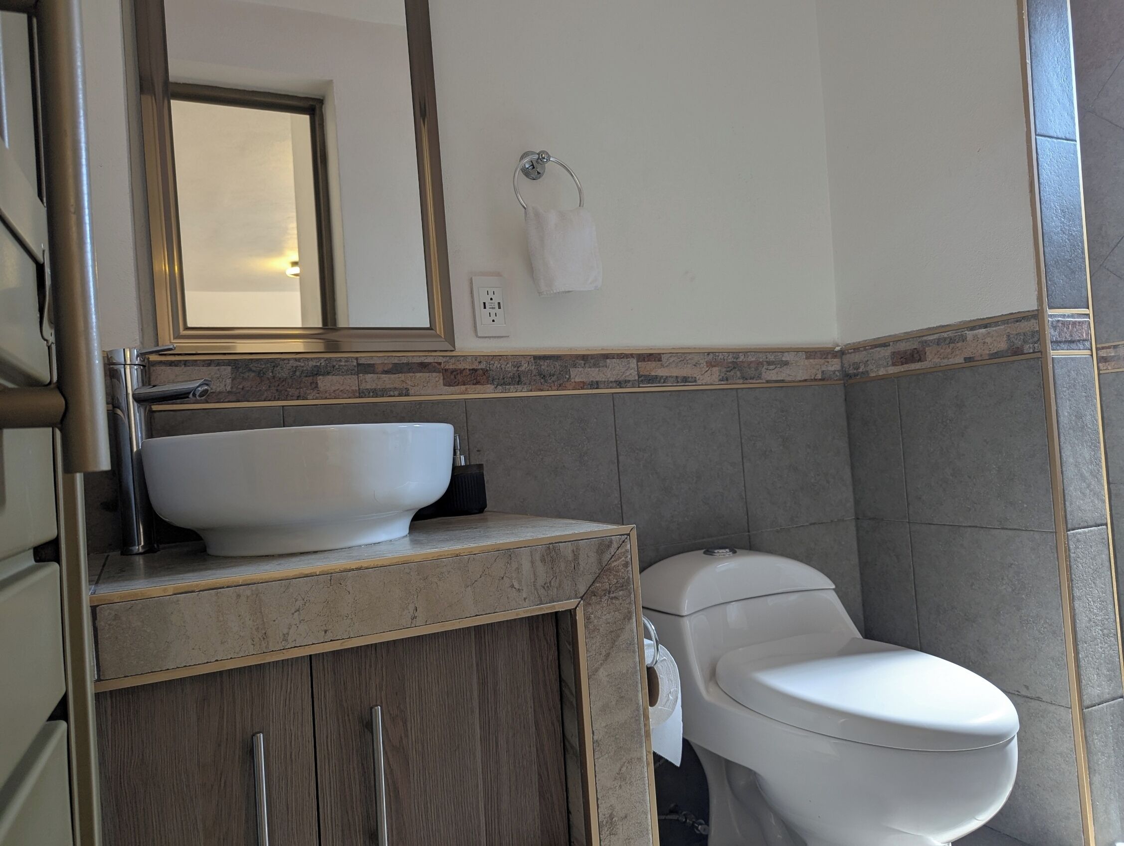 A bathroom with a white sink, a toilet, and a mirror above the sink.