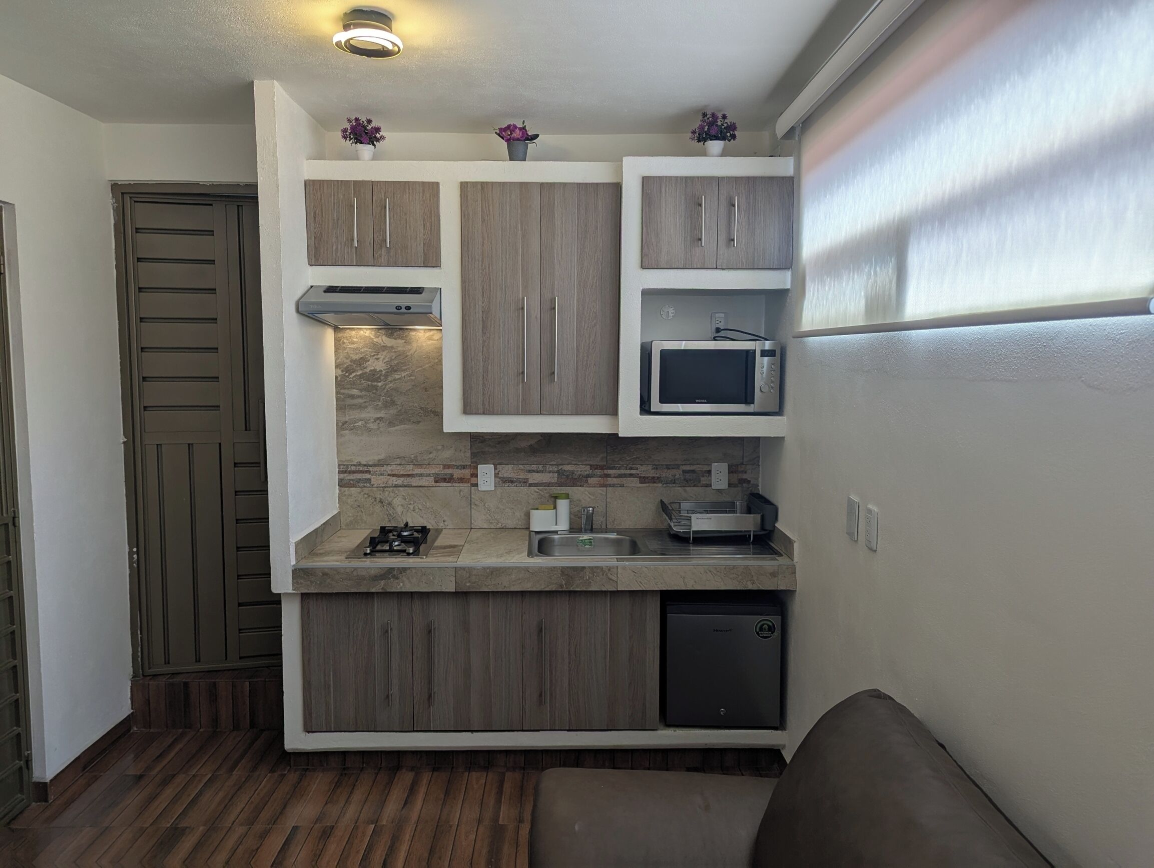 A compact kitchen with a built-in microwave, a gas stove, and a dishwasher.