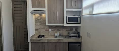 A compact kitchen with a built-in microwave, a gas stove, and a dishwasher.