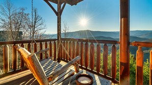 A wooden deck with a swing chair and a bowl, overlooking a mountainous landscape. - Amazing Mtn views/Hot tub/Fireplace/Bunk beds/Arcade games (Sevierville)