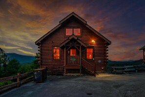 A log cabin with a porch, a staircase, and a sign indicating a view.