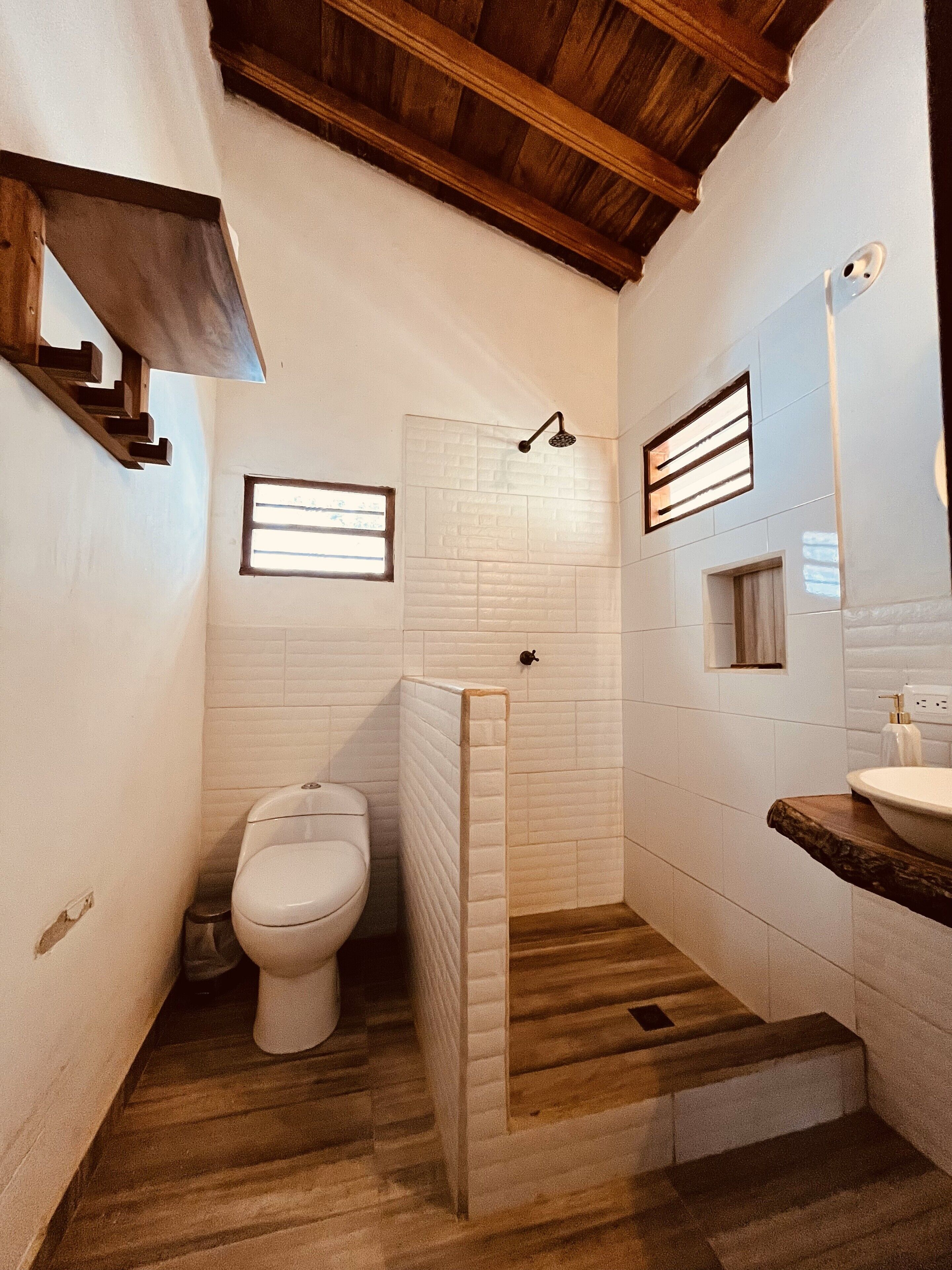 Un baño con inodoro, ducha y lavamanos.