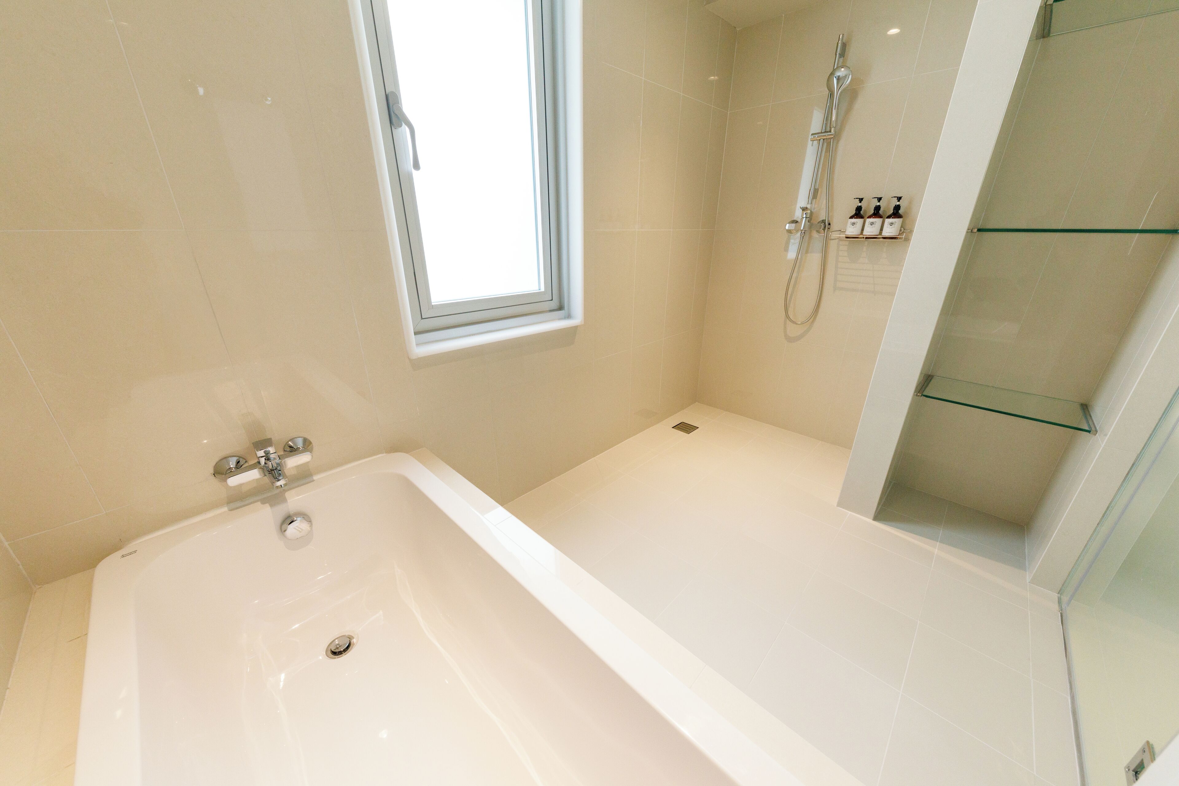 Un bagno moderno con vasca, doccia e finestra.