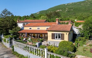 A row of terraced houses with red-tiled roofs, a white fence, and lush greenery. - 2 bedroom stunning home in Plomin (Plomin)